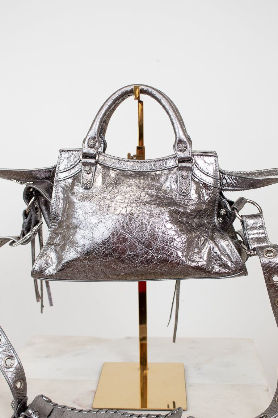 Back view of silver metallic crinkled texture handbag with detailed rhinestone accents on a light background