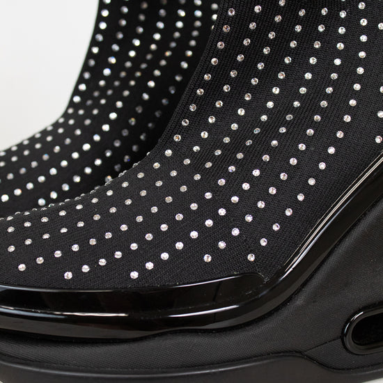 Black ankle boots with silver studs and a brand logo on a light background