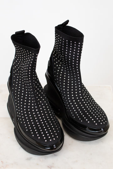 Black ankle boots with silver stud details on a light background