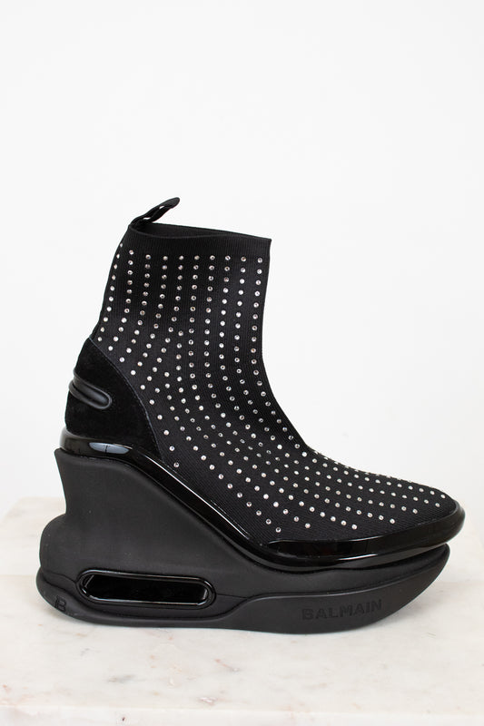 Black studded ankle boot with a wedge sole on a white background