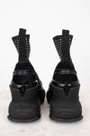 Black high-heeled shoes with silver studded details on a white background