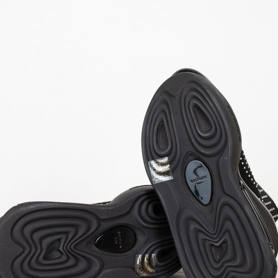 Black boots with athletic unique sole design on a light gray and white background
