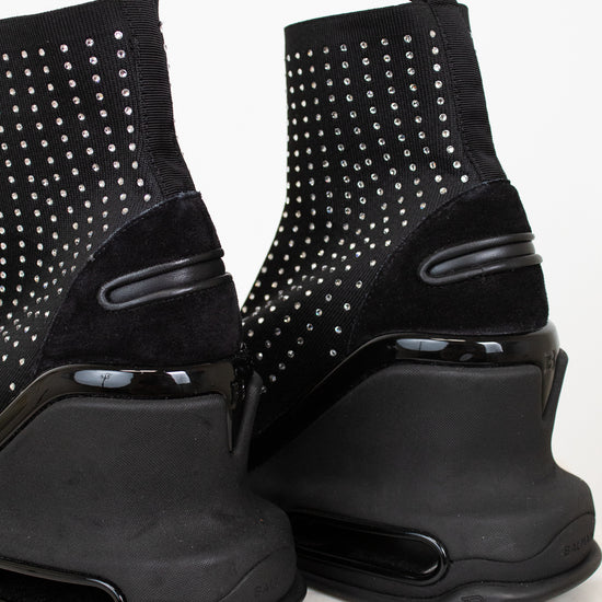 Black studded ankle boots on a white background
