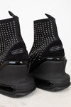 Black studded ankle boots on a white background