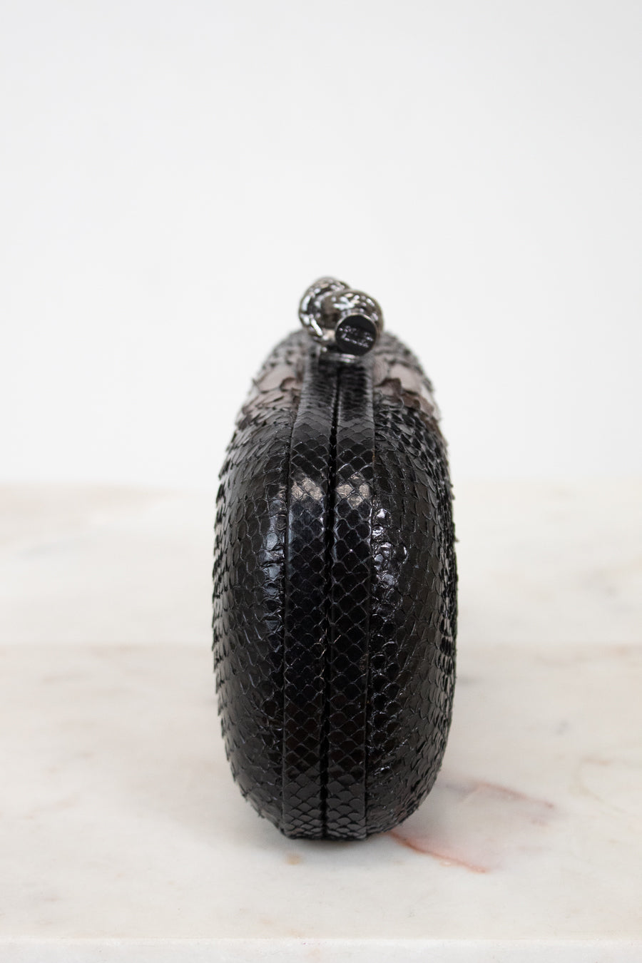 Black textured clutch bag on a white background