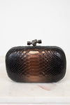 Black snakeskin clutch bag on a light background