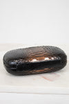 Black textured clutch on a white surface