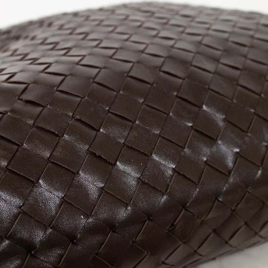 Close-up of a brown woven leather oversized tote on a light background