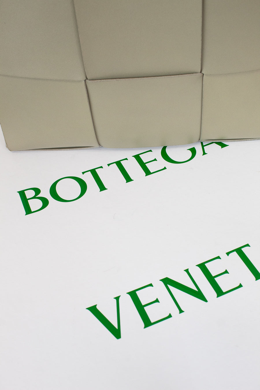 Close-up of a Bottega Veneta product with green text on a white background