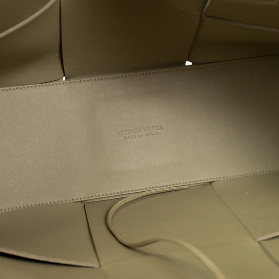 Close-up of a light green leather interior with a visible brand logo.