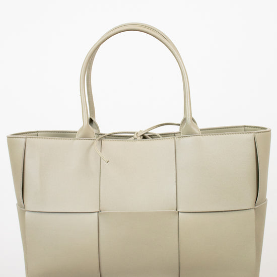 Light green woven handbag on a white background