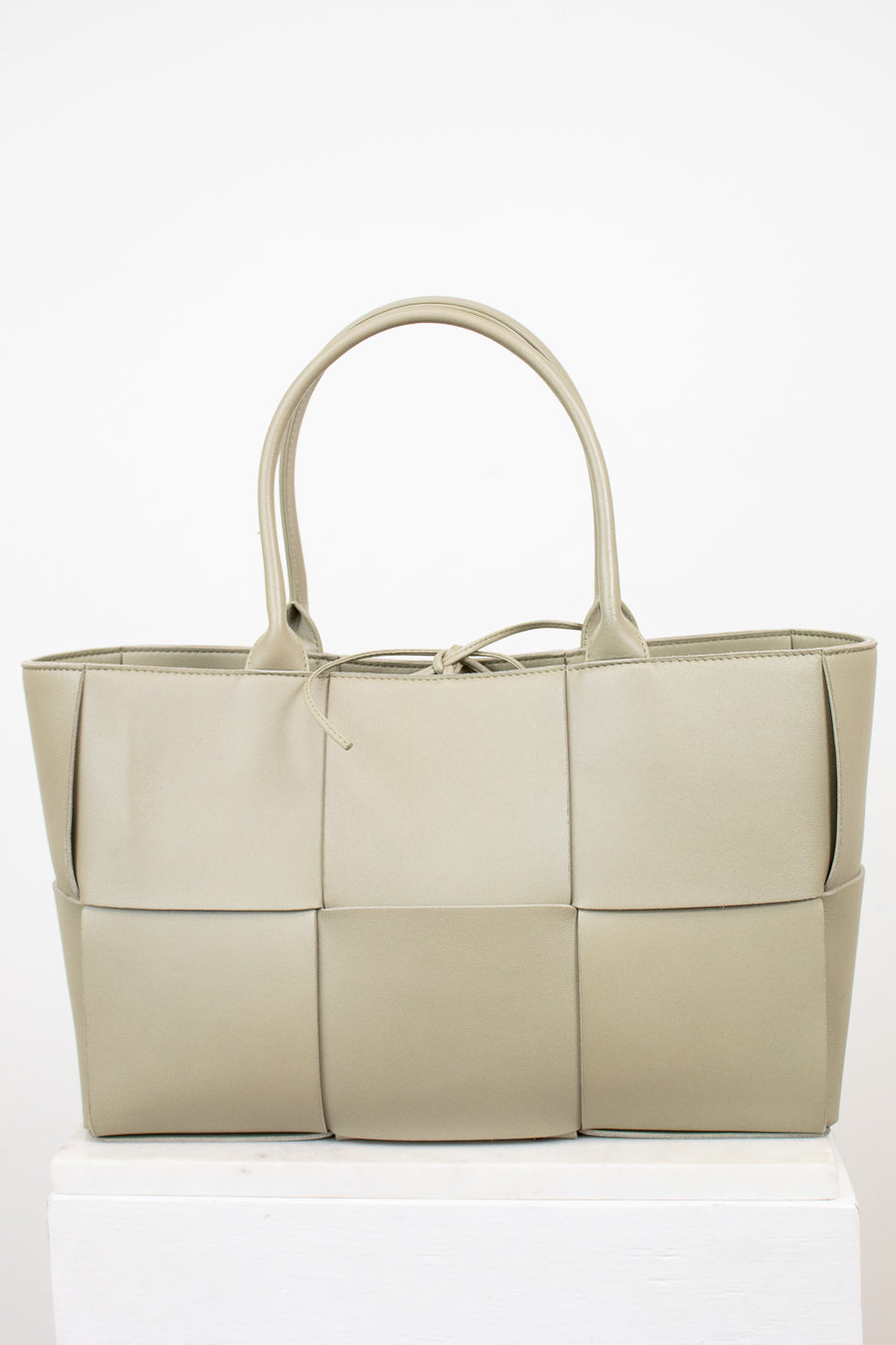 Light green woven handbag on a white background