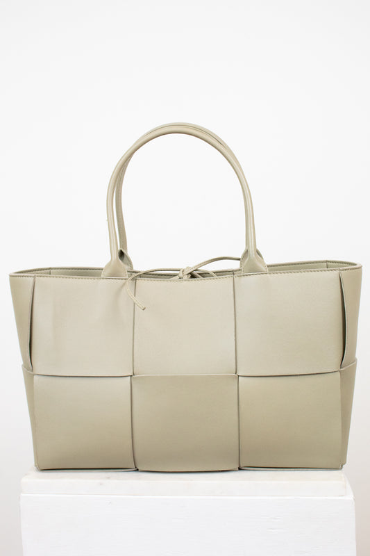 Light green woven handbag on a white background