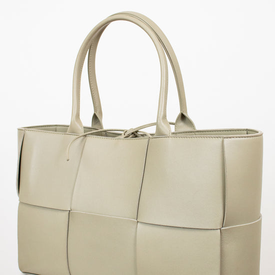 Light green woven handbag on a white background