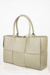 Light green woven handbag on a white background