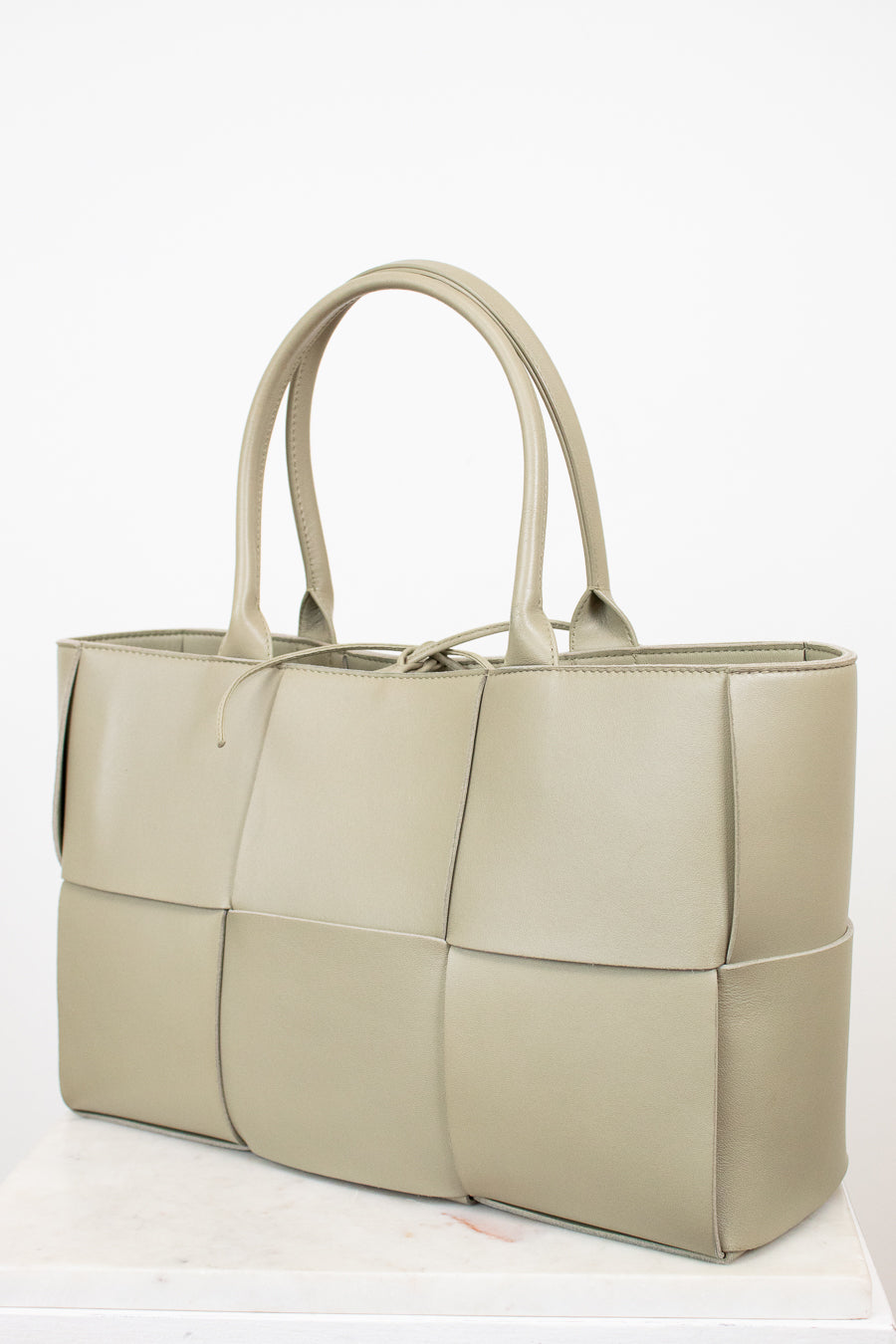 Light green woven handbag on a white background