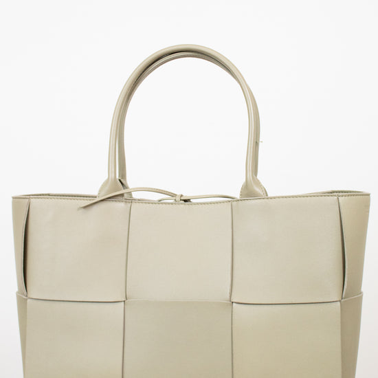 Light green woven handbag on a white background