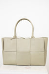 Light green woven handbag on a white background