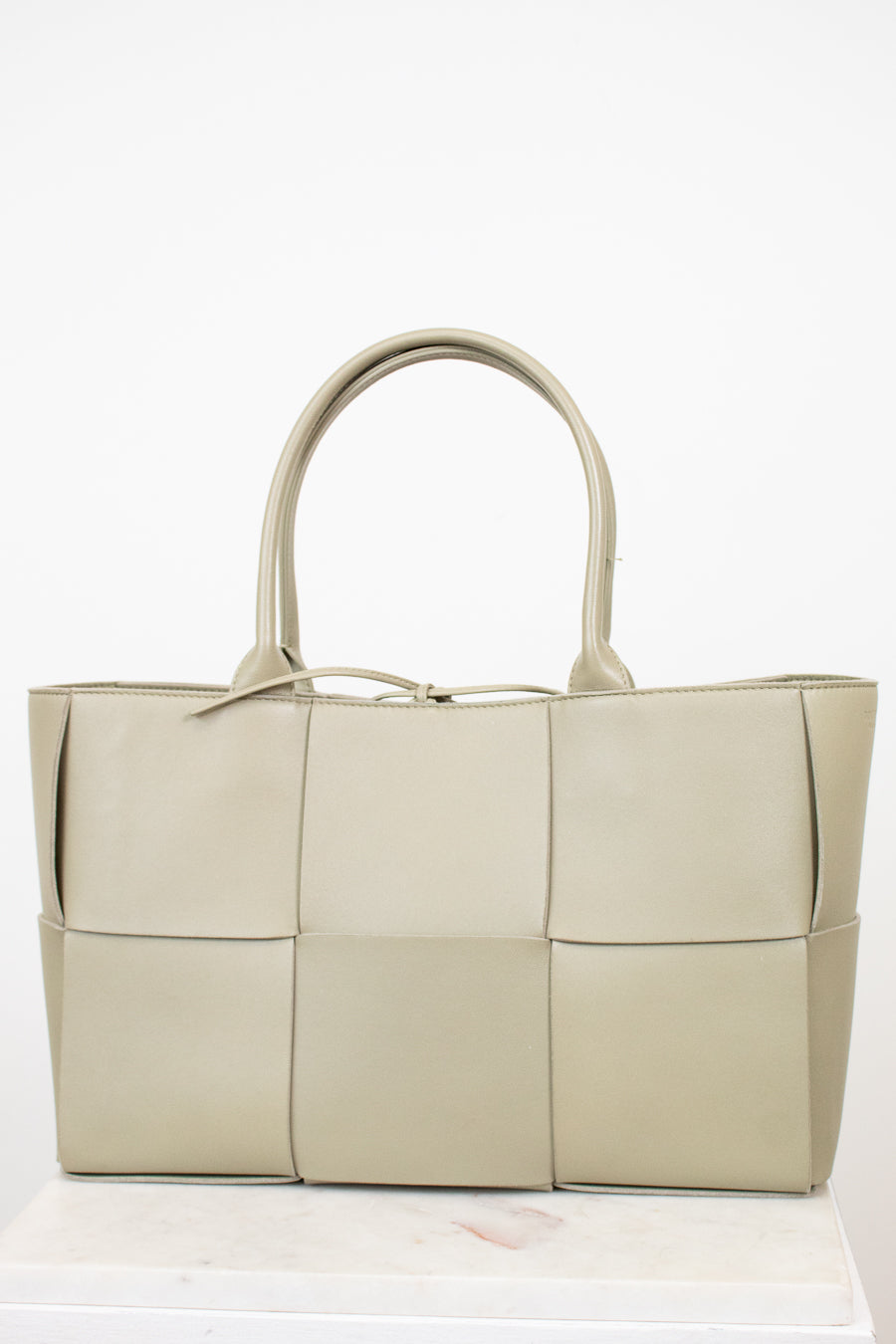 Light green woven handbag on a white background