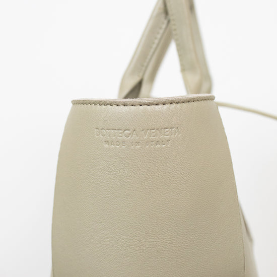 Light green woven handbag on a white background with Bottega Veneta branding stamp