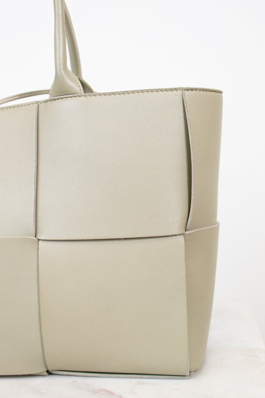 Light green woven handbag on a white background