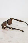 Sunglasses with tortoiseshell frame and brown lenses on a marble surface