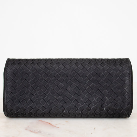 Black woven clutch bag on a marble surface