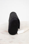 Black rectangular woven clutch on a light marble surface