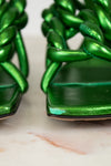 Close-up of green woven sandals on a marble surface