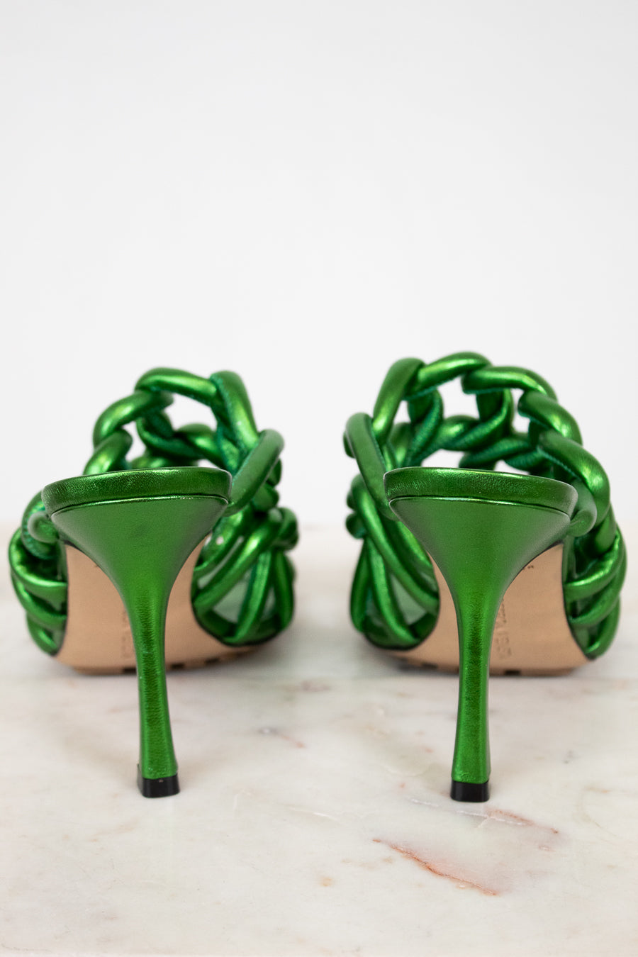 Pair of green high-heeled shoes on a white background