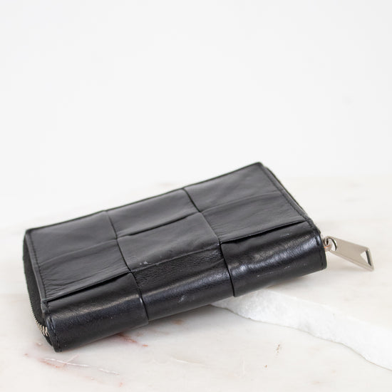 Black leather wallet on a white marble surface