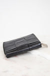 Black leather wallet on a white marble surface