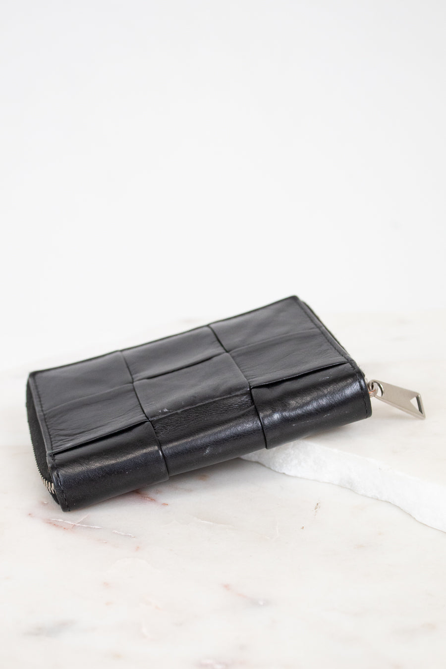 Black leather wallet on a white marble surface