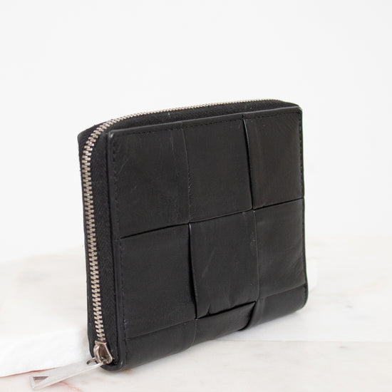 Black leather clutch bag with geometric design on a white background