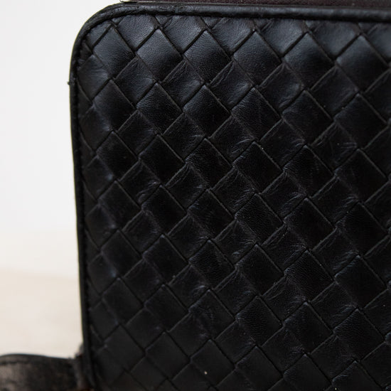 Black woven leather wallet on a light background