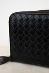 Black woven leather wallet on a light background
