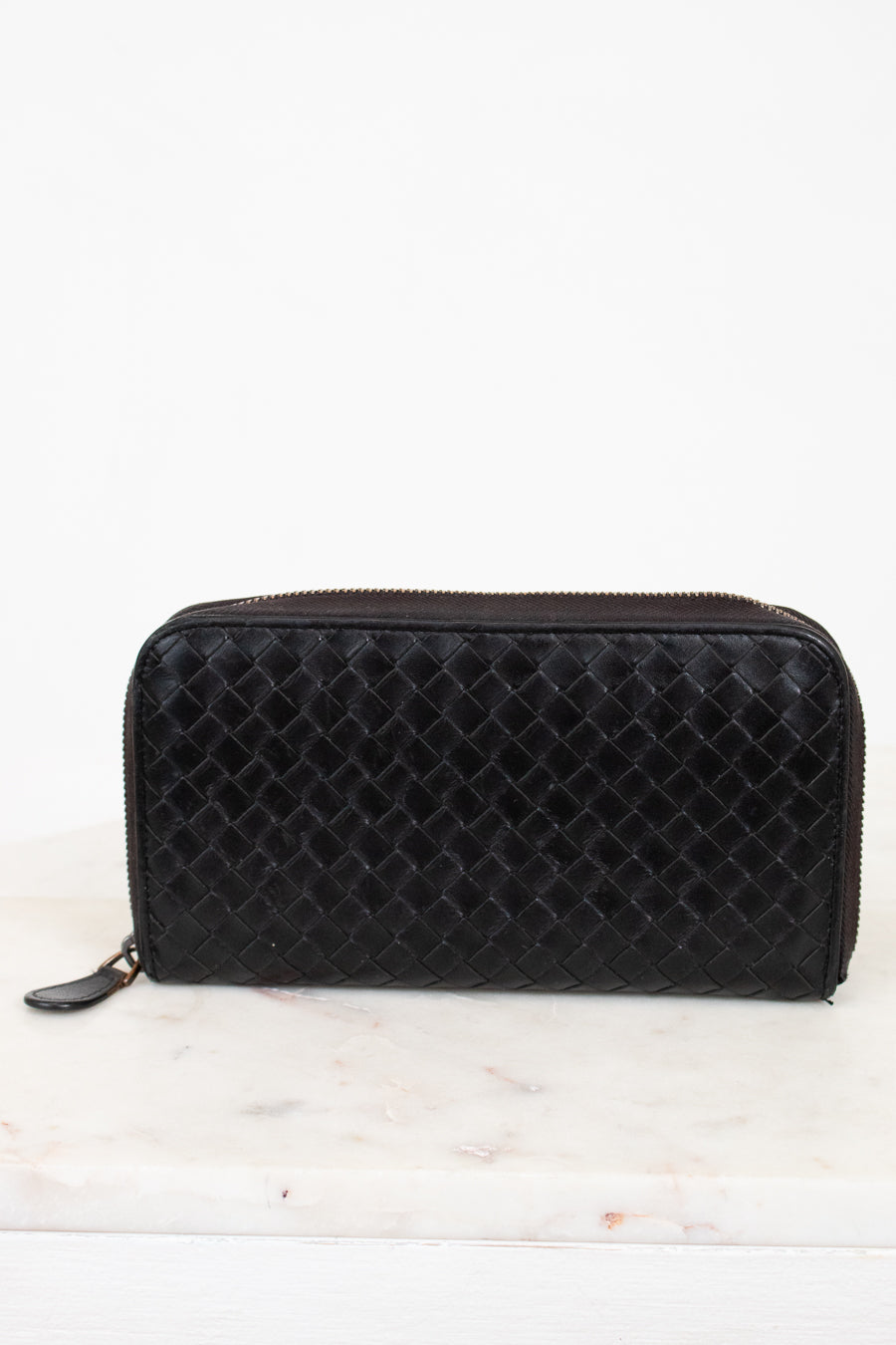 Black woven wallet on a white background