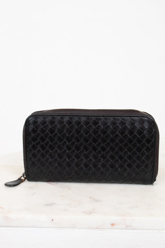 Black woven wallet on a white background
