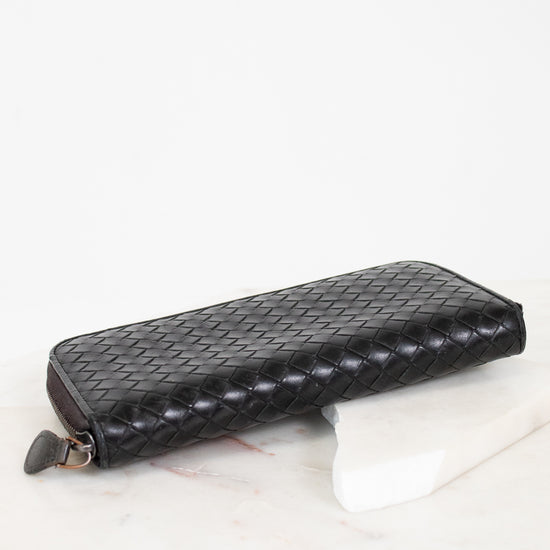 Black woven wallet on a white surface
