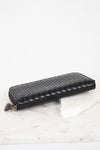 Black woven wallet on a white surface