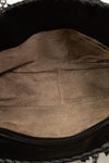 Close-up of a brown leather bag interior with visible stitching