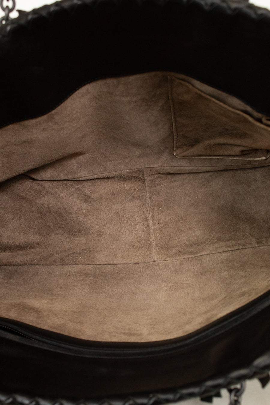Close-up of a brown leather bag interior with visible stitching