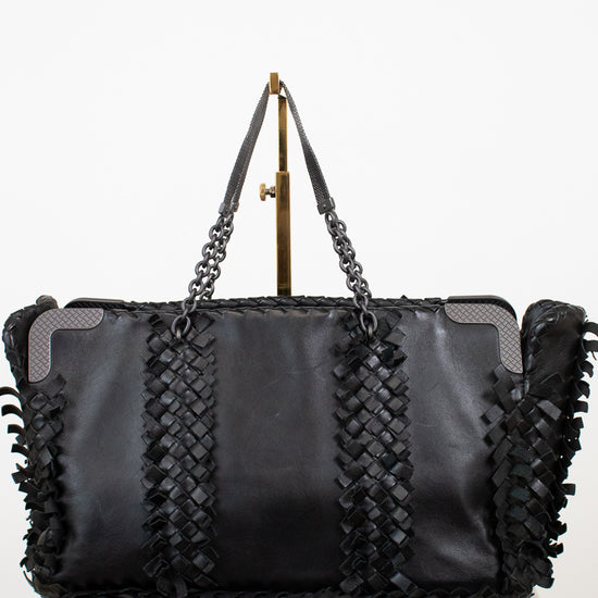 Black leather handbag with braided design and chain strap on a white background