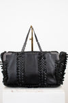 Black leather handbag with braided design and chain strap on a white background