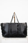 Black woven handbag with chain detail on a white background