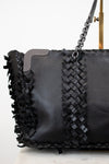 Black handbag with woven detail and chain strap on a white background
