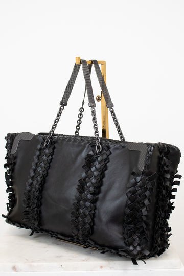 Black handbag with woven straps on a white background