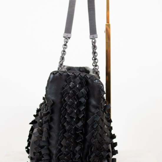 Black textured handbag with chain details on a white background