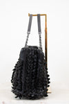 Black textured handbag with chain details on a white background