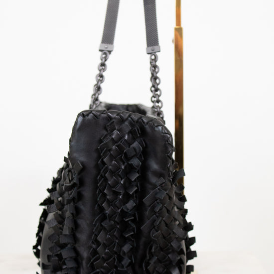 Black textured handbag with chain details on a white background